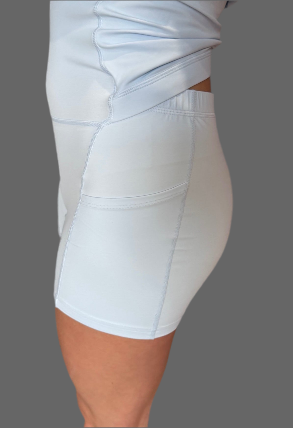 Side view of baby blue Athena Active Dress by Sportik athletikS, showing built-in shorts with pocket and Easy Peezy lift-up design for functional movement